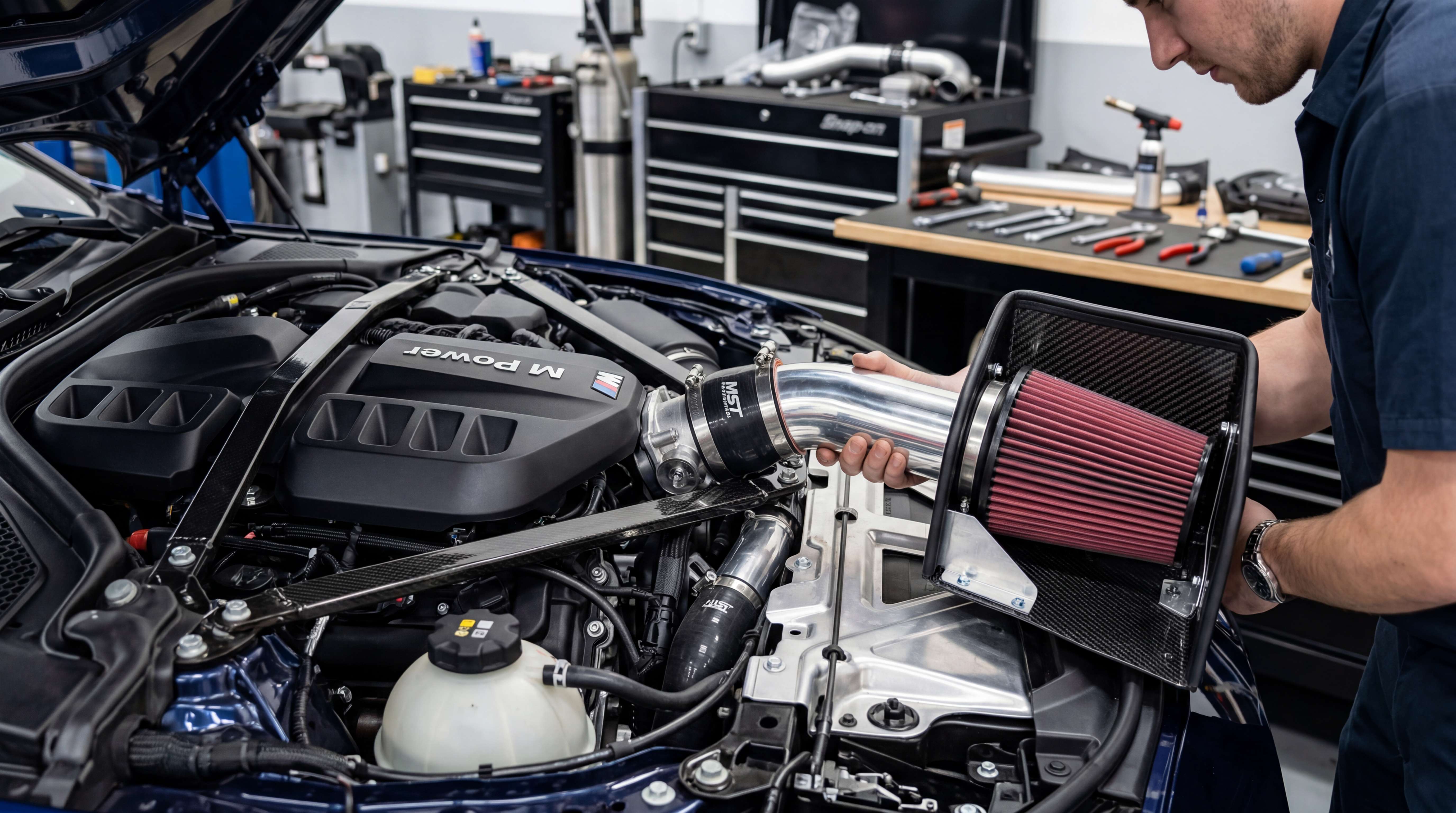 Technician installing a vehicle-specific air intake kit and checking engine bay fitment, filter position and mounting clearance